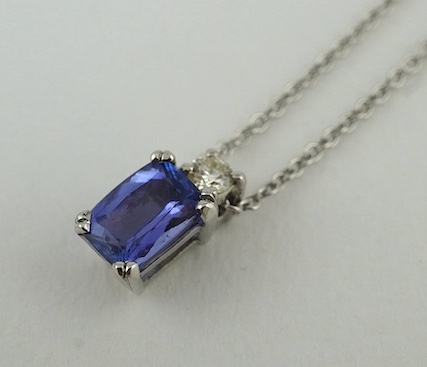 A modern 18ct white gold, tanzanite and diamond set pendant, 10mm, on an 18ct white gold chain, 39cm, gross weight 3.1 grams. Condition - good